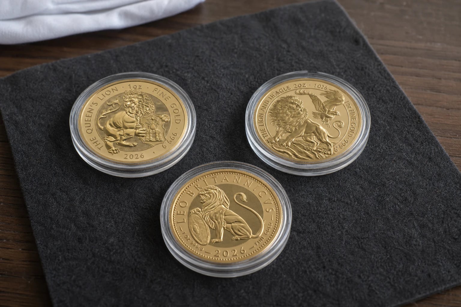 Three 2026 gold coins in capsules arranged on a Bullion House presentation mat