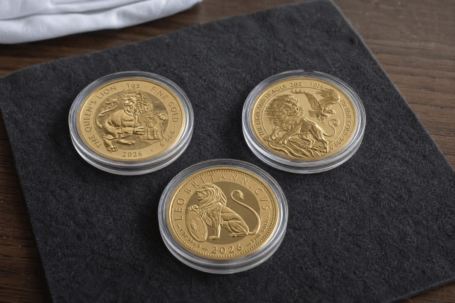 Three 2026 gold coins in capsules arranged on a Bullion House presentation mat