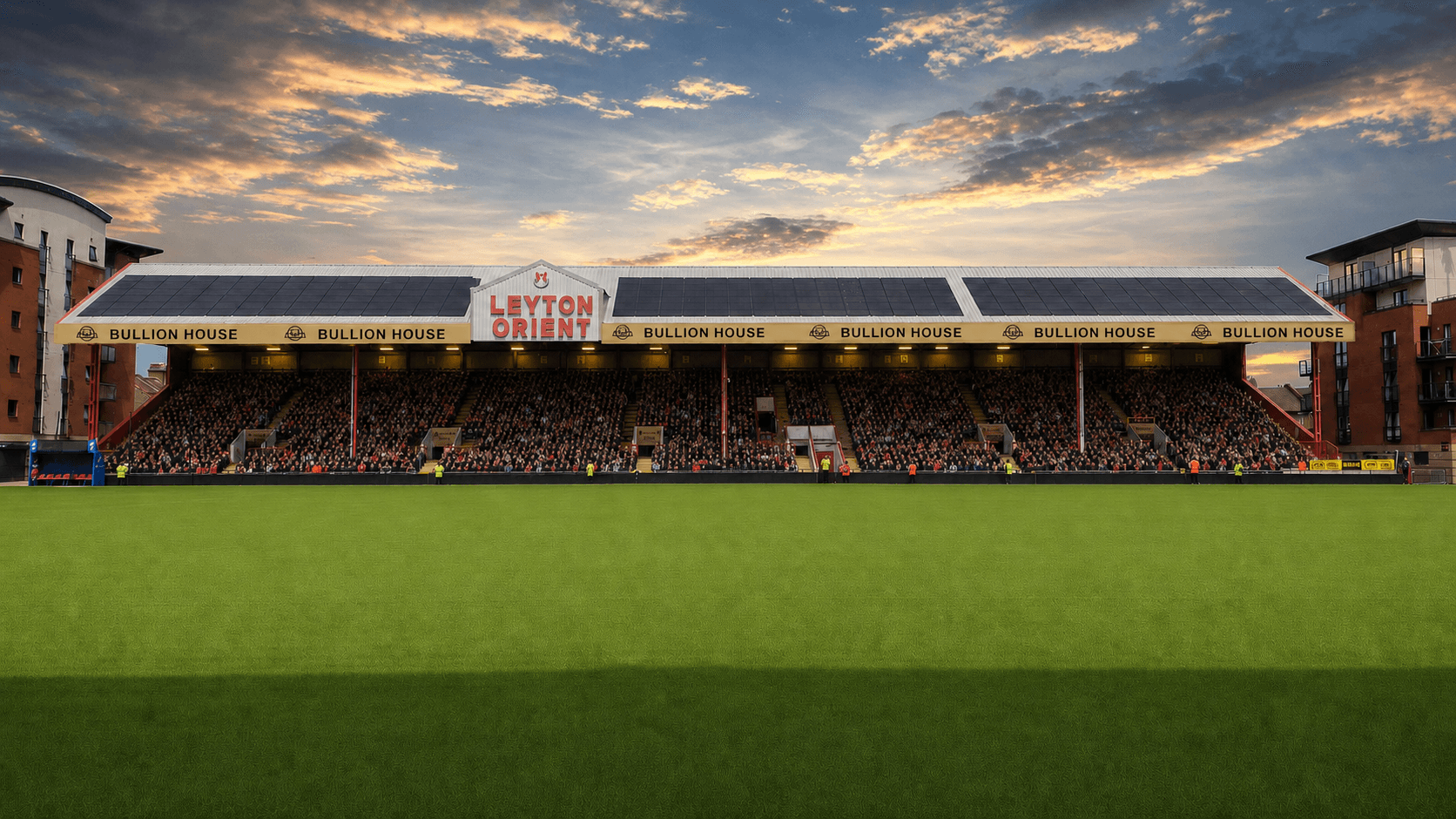 A full East Stand at Brisbane Road beneath Bullion House signage on matchday