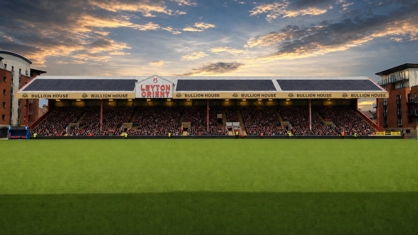 A full East Stand at Brisbane Road beneath Bullion House signage on matchday