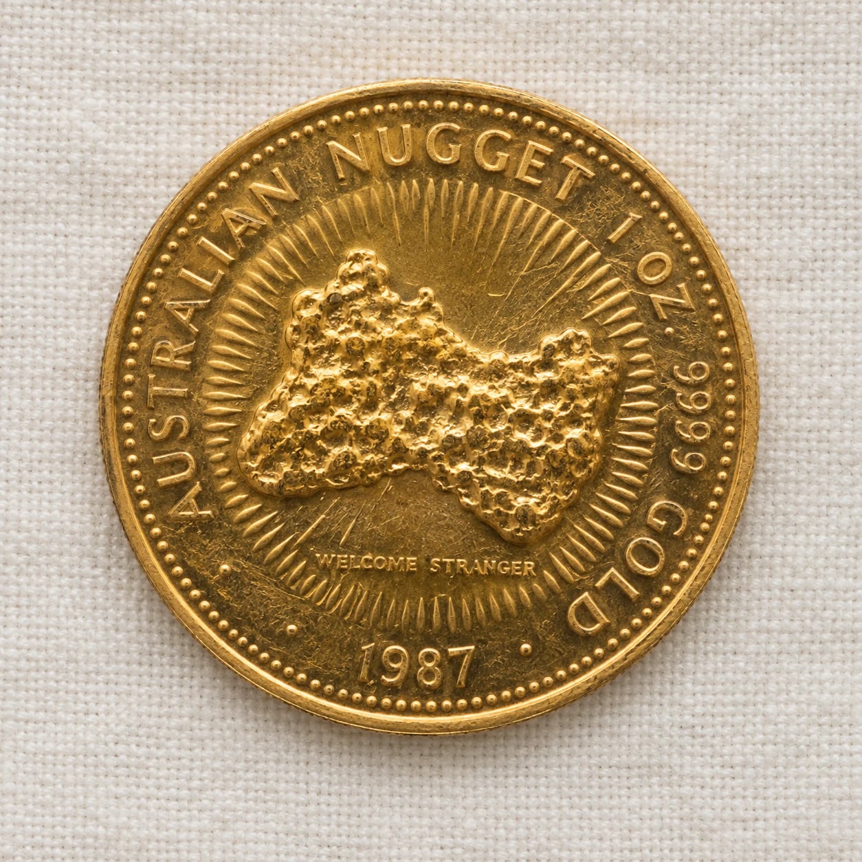 A complete handled 1987 one-ounce Australian Gold Nugget coin showing the Welcome Stranger nugget