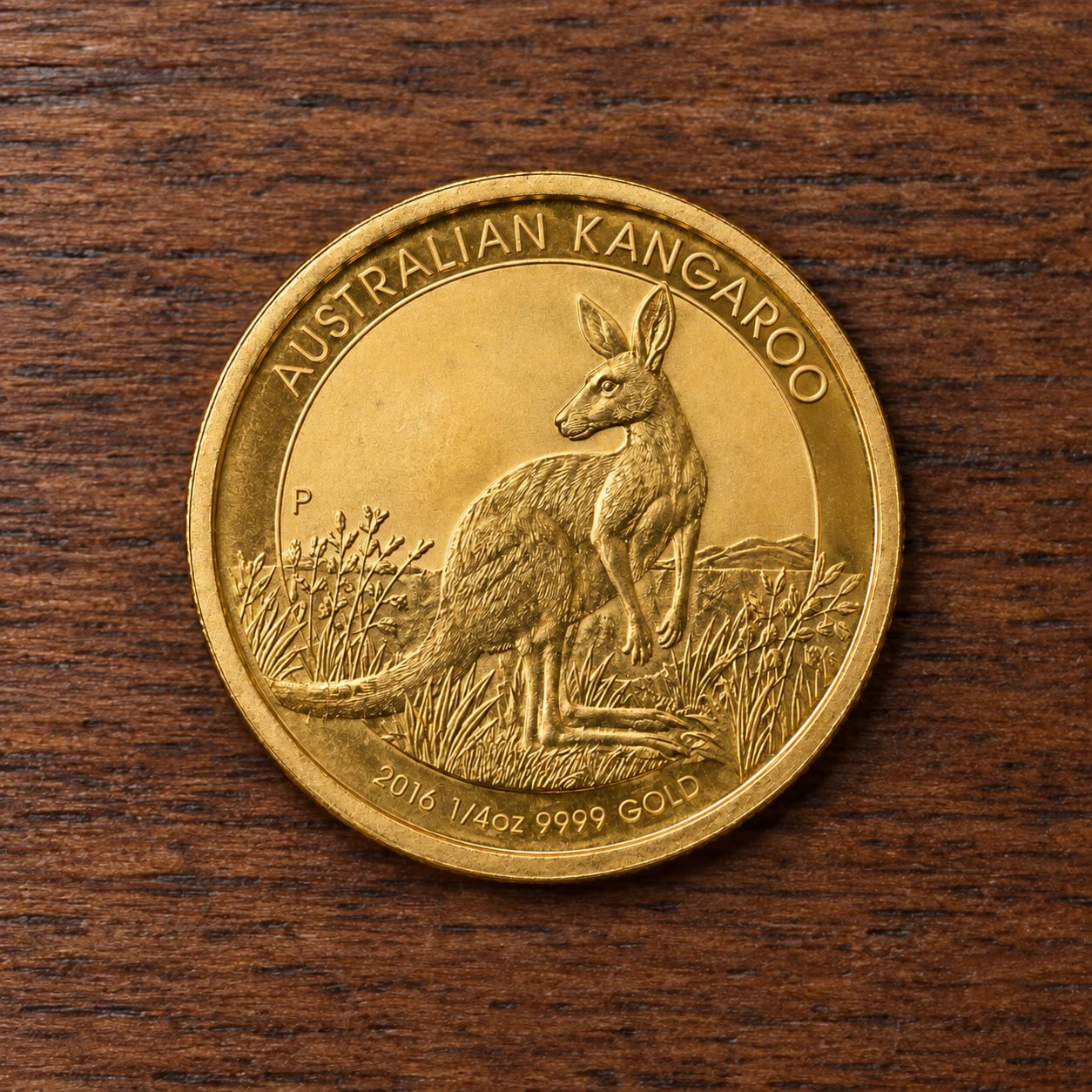 A complete 2016 quarter-ounce Australian Gold Kangaroo coin with a satin finish on walnut
