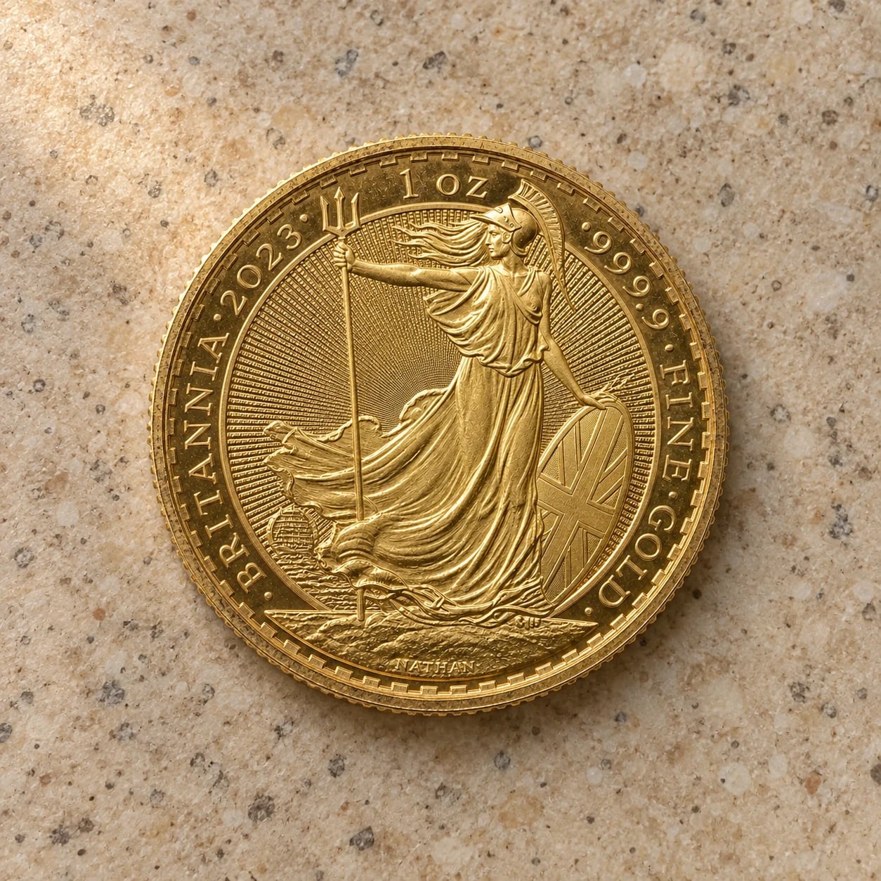 A complete handled 2023 one-ounce Gold Britannia coin on a speckled kitchen tile
