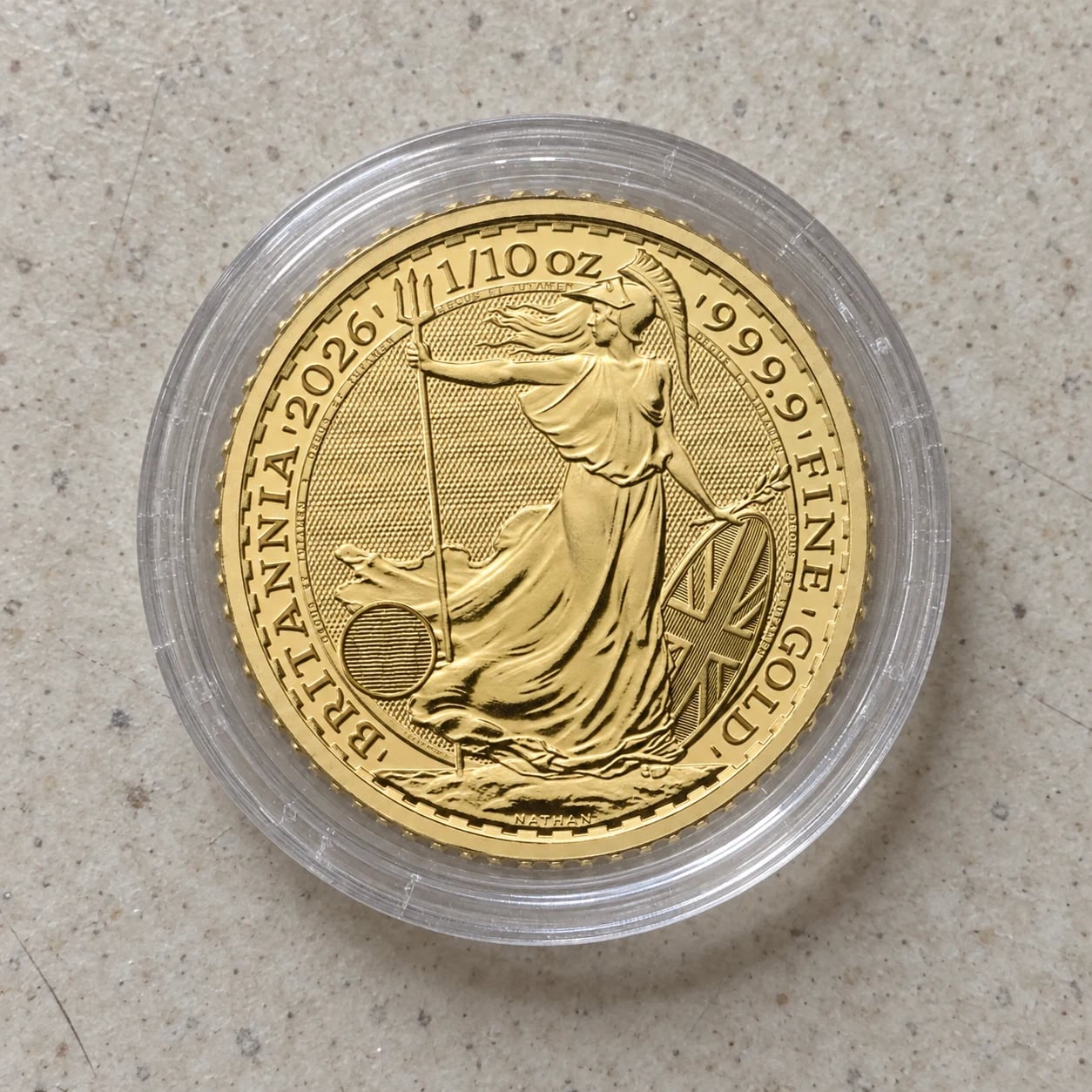 A complete 2026 one-tenth-ounce Gold Britannia coin in a clear capsule