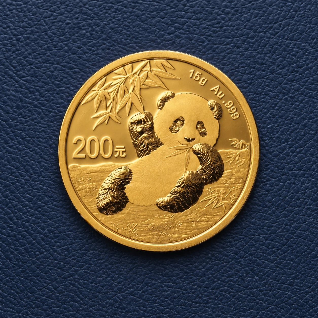 A complete crisp 15g Chinese Gold Panda coin with a seated panda design on navy leather