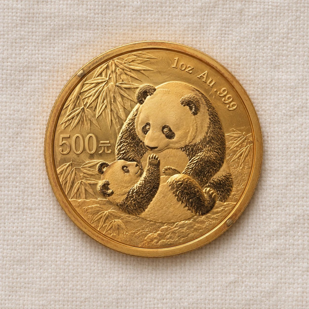 A complete older one-ounce Chinese Gold Panda coin with a mother-and-cub design and warm toning