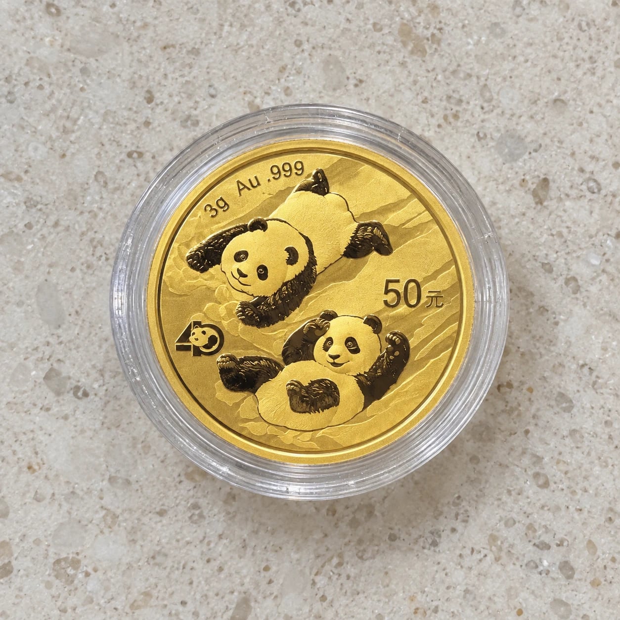 A complete bright 3g Chinese Gold Panda coin with the 2022 two-panda design in a clear capsule