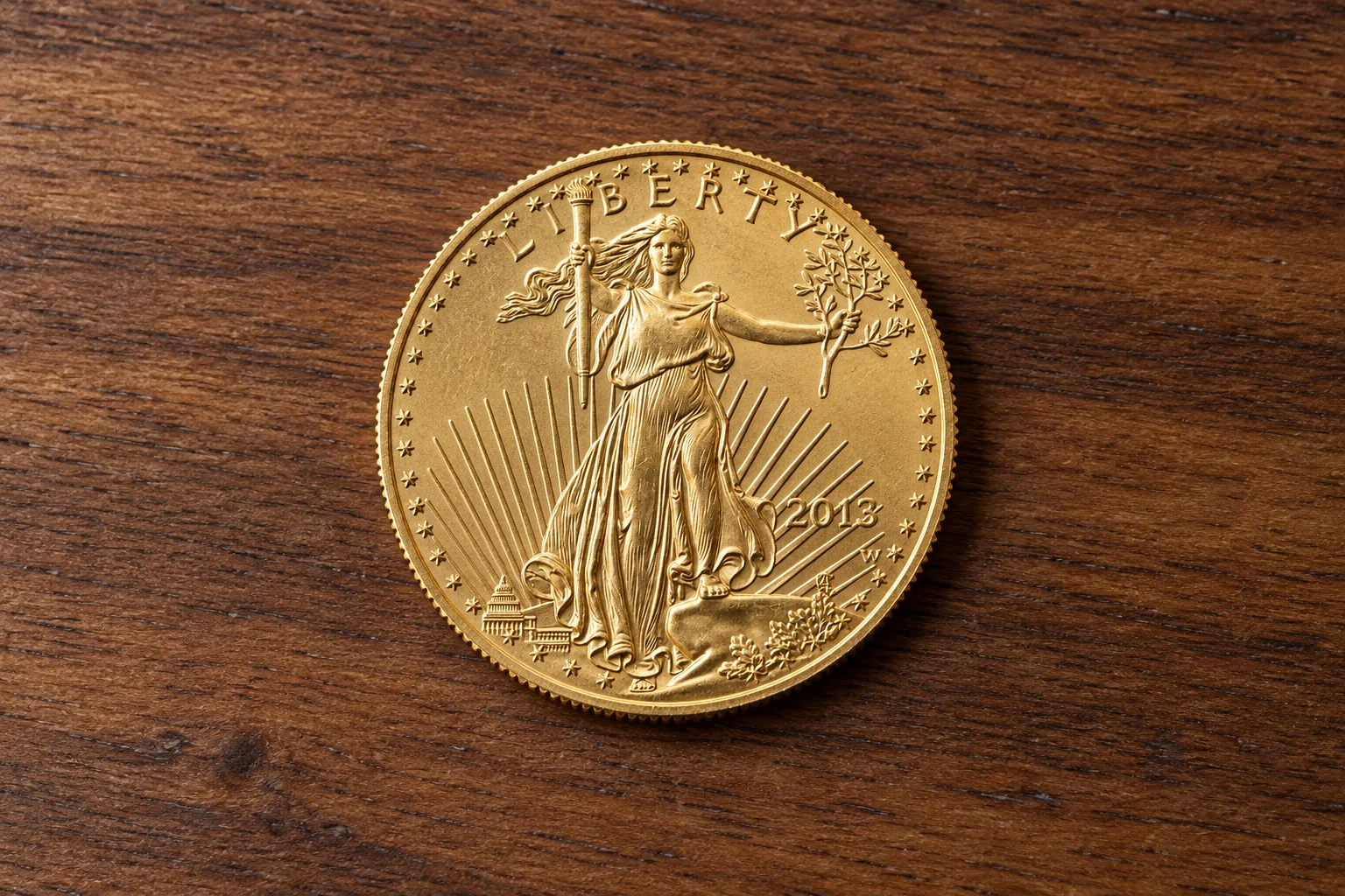 A complete one-ounce American Gold Eagle coin lying flat on a clean walnut table