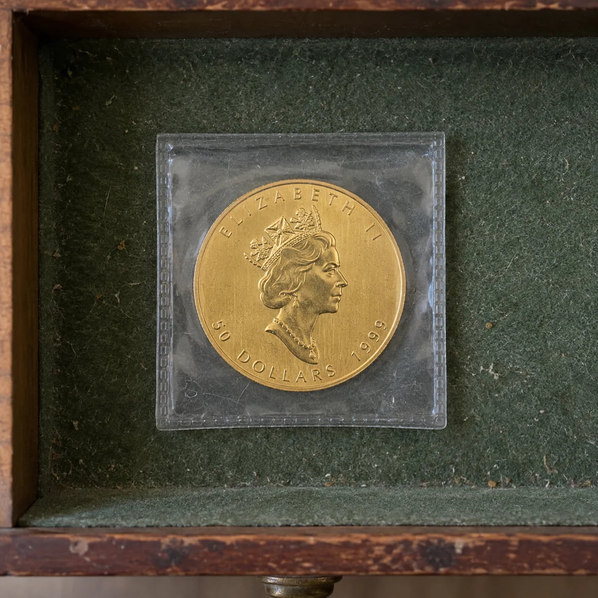 A complete Queen Elizabeth II Canadian Gold Maple Leaf coin stored in a drawer