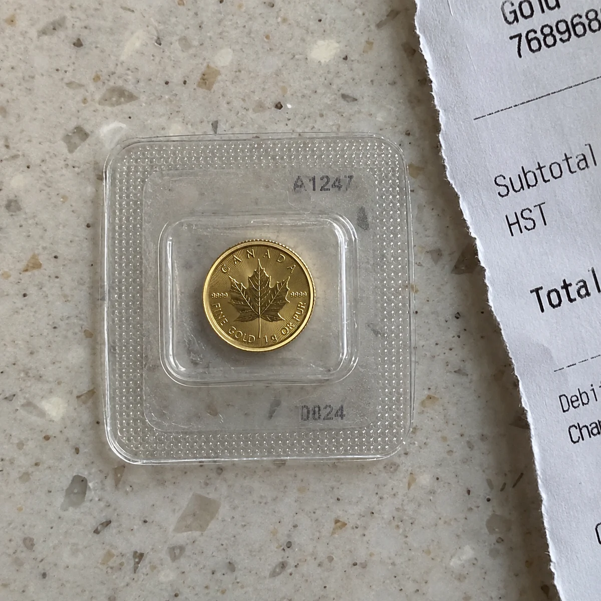 A complete tiny one-gram Canadian Gold Maple Leaf coin in a Maplegram blister