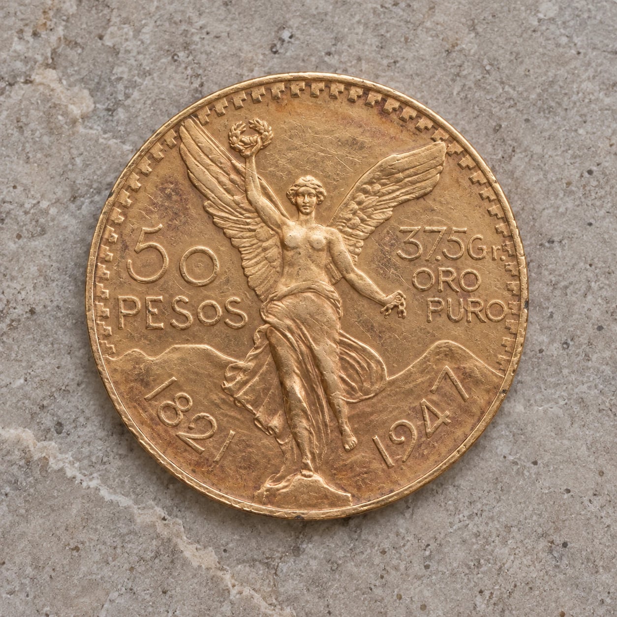 A complete handled 1921 Mexican 50 Pesos Centenario gold coin showing Winged Victory