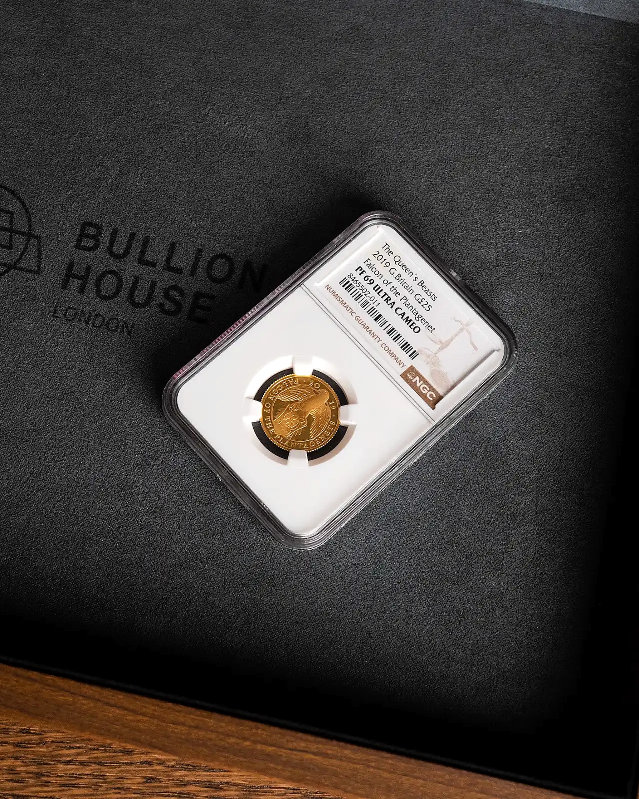 An NGC-graded gold coin in its certification slab on a Bullion House presentation case