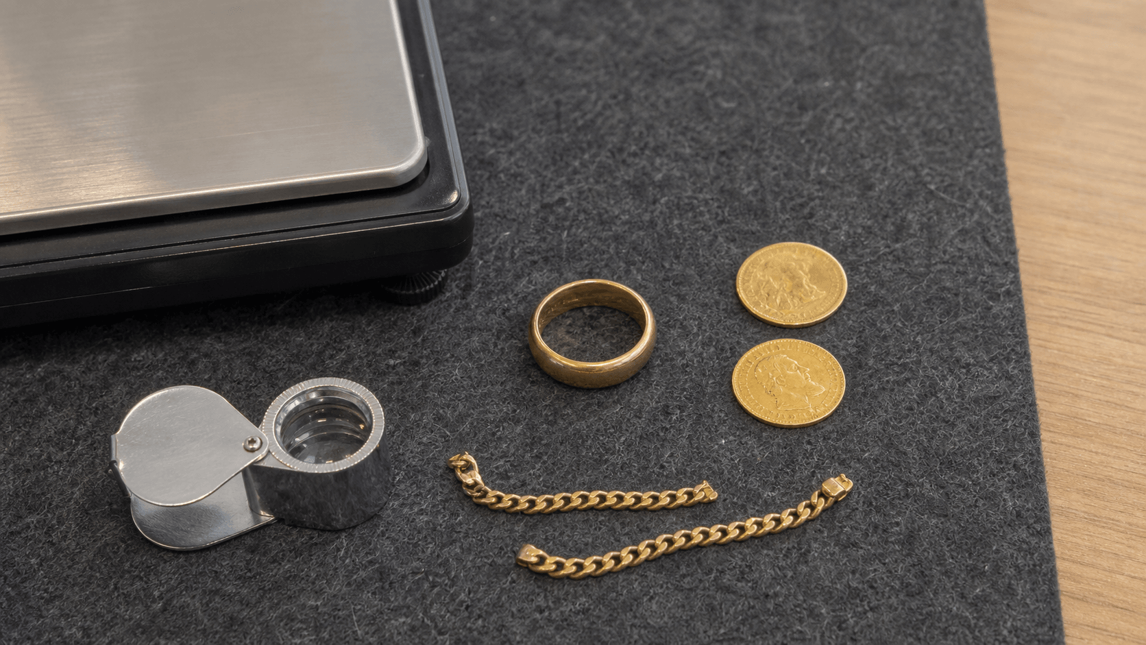 Gold items arranged for assessment on a felt valuation mat